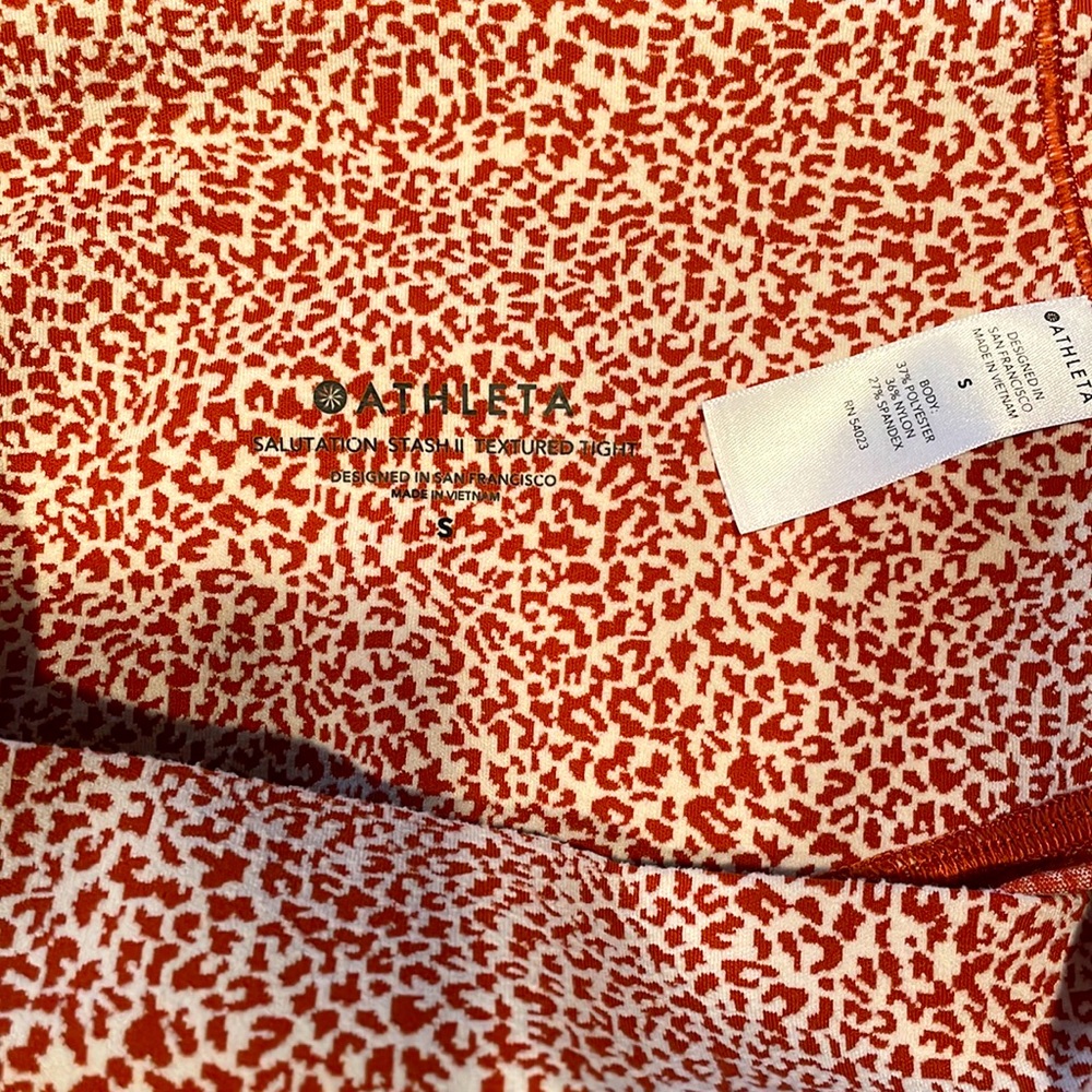 Athleta Salutation Stash ll textured tight, orange and white, size small